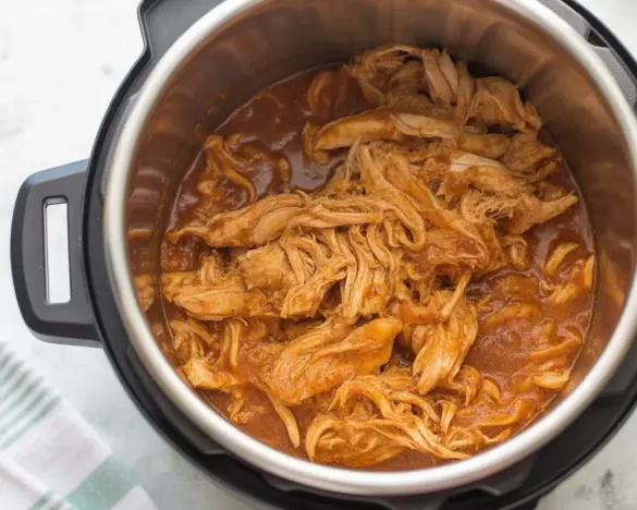 30-Minute Instant Pot BBQ Pulled Chicken served with a side of coleslaw and buns.
