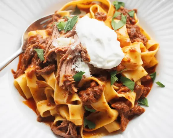 Delicious Slow Cooker Beef Ragu with Pappardelle served in a bowl with fresh herbs.